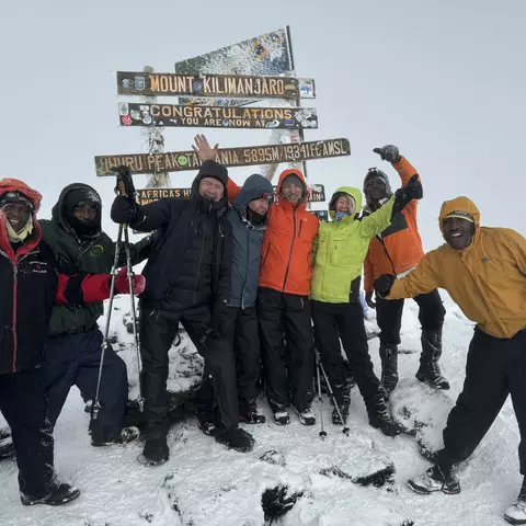 Four mountaineers from Karlsruhe with their mountain guides at the summit of Kilimanjaro